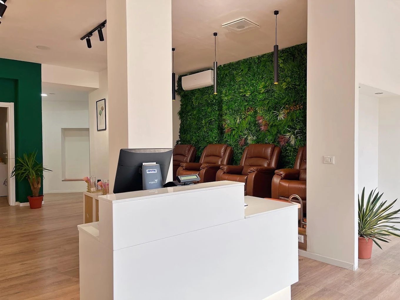 Area reception moderna del salone Holly Nail SPA con muro verde